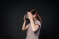 Little girl take photo with vintage camera at black background Royalty Free Stock Photo