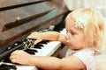 The little girl takes the clarinet lying on the black piano keys Royalty Free Stock Photo