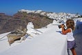 little girl takes pictures of beautiful views of Santorini