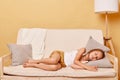 Little girl taking day nap, sleeping on cozy comfortable couch at home, cute adorable kid child with closed eyes lying resting on Royalty Free Stock Photo