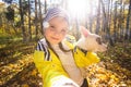 Little girl taking selfie with her dog at autumn park. Child posing with jack russell terrier for a picture on the Royalty Free Stock Photo