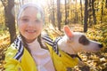 Little girl taking selfie with her dog at autumn park. Child posing with jack russell terrier for a picture on the Royalty Free Stock Photo