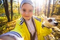 Little girl taking selfie with her dog at autumn park. Child posing with jack russell terrier for a picture on the Royalty Free Stock Photo