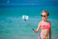 Little girl taking selfie portrait with her smartphone on the beach. Adorable model making selfportrait background Royalty Free Stock Photo