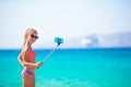 Little girl taking selfportrait by her smartphone on the beach. Kid enjoying her suumer vacation and making photos Royalty Free Stock Photo