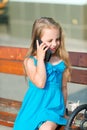 Little girl talk on cell phone on park bench, summer Royalty Free Stock Photo