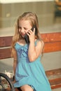 Little girl talk on cell phone on park bench, summer Royalty Free Stock Photo