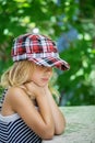 Little girl talking in plaid cap
