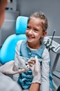 Little girl talking to the dendist. Child in the dentist`s office