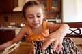 Little girl tasting chocolate cream from a homemade cherry pie at home kitchen interior Royalty Free Stock Photo