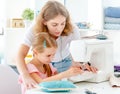 Little girl is taught to sew