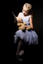 Little girl with a teddy bear on a black background. Royalty Free Stock Photo