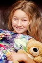 Little girl with a teddy bear on a black background. Royalty Free Stock Photo