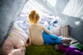 Little girl with teddy bear in camp tent looking at the sea Royalty Free Stock Photo