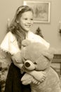 Little girl with a Teddy bear near the fireplace. Royalty Free Stock Photo