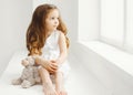 Little girl with teddy bear toy at home in white room Royalty Free Stock Photo