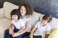 Little girl, teen boy and curly hair girl wirh laptop on sofa a Royalty Free Stock Photo