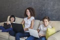 Little girl, teen boy and curly hair girl wirh tablet and laptop Royalty Free Stock Photo