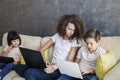 Little girl, teen boy and curly hair girl wirh tablet and laptop Royalty Free Stock Photo