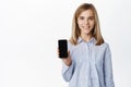 Little girl, teen child showing smartphone screen, mobile phone app display, smiling and looking happy at camera Royalty Free Stock Photo