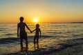 Little girl and teenager bathing on a beach at sunset Royalty Free Stock Photo