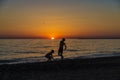 Little girl and teenager playing on a beach at sunset Royalty Free Stock Photo