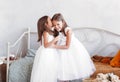 little girl tells the secret to her sister in her ear. Children play in the room