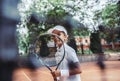 Little girl with tennis racket in sport club. Cropped image of a sporty little girl with racket playing tennis outdoors. Child