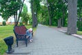 Little girl with thoughtful look sitting on bench in city park and thinking Royalty Free Stock Photo