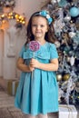 Little girl three years in a blue dress licks Royalty Free Stock Photo