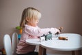 Little girl toddler playing with animal toys on table in children`s room at home Royalty Free Stock Photo