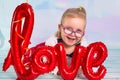 Little girl toddler with red heart balloonand love sign. Valentines day concept Royalty Free Stock Photo