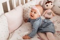 Little girl Todler in the cot smiles. Child after awakening