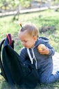 Little girl took out an apple from a backpack while sitting on her lap on a green lawn Royalty Free Stock Photo