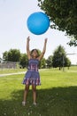 Little girl tossing up ball