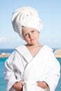 Little girl with towel on head in white bathrobe