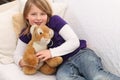 Little girl with toy tiger on sofa Royalty Free Stock Photo
