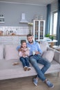 Little girl with toy, young man with remote control and cup. Royalty Free Stock Photo