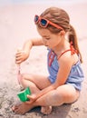 Little girl, toys and playing with beach sand, castle or summer fun on outdoor holiday or weekend in nature. Female Royalty Free Stock Photo