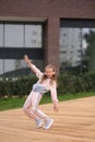 Little girl in a tracksuit is dancing modern dance on the street. Young urban hip hop dancer Royalty Free Stock Photo