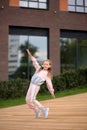 Little girl in a tracksuit is dancing modern dance on the street. Young urban hip hop dancer Royalty Free Stock Photo