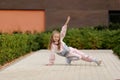 Little girl in a tracksuit is dancing modern dance on the street. Young urban hip hop dancer Royalty Free Stock Photo