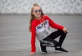 Little girl in a tracksuit is dancing modern dance on the street. Young urban hip hop dancer Royalty Free Stock Photo