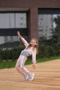 Little girl in a tracksuit is dancing modern dance on the street. Young urban hip hop dancer Royalty Free Stock Photo