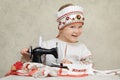 Little girl in the traditional russian shirt and kokoshnik at the process of sewing