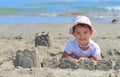 Little girl at tropical beach making sand castle in summer Royalty Free Stock Photo