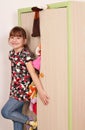 Little girl trying to close messy closet Royalty Free Stock Photo
