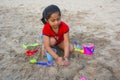 Little girl trying to make a fort with sand on Alibag beach, India Royalty Free Stock Photo