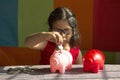 Little girl trying to put coins in her piggy bank, Pune, India Royalty Free Stock Photo