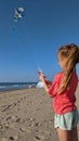 Little girl trying to untangle her knotted kite string on the beach Royalty Free Stock Photo